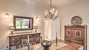 A dining room with a wooden table, a chandelier, and a mirror above the table. - Private Home w/ Hot Tub Near Jay Peak Slopes (Montgomery Center)