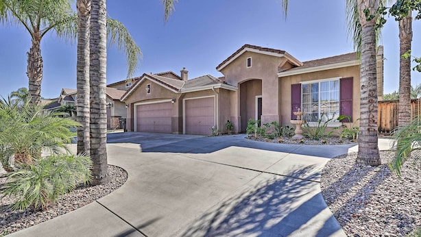 A residential area with two houses, each with a garage, surrounded by palm trees and a well-maintained driveway. - Incredible Wildomar Getaway w/ Outdoor Oasis! (Wildomar)