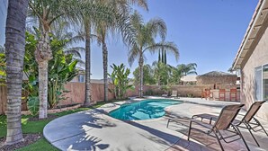 A backyard with a swimming pool, palm trees, and outdoor furniture. - Incredible Wildomar Getaway w/ Outdoor Oasis! (Wildomar)