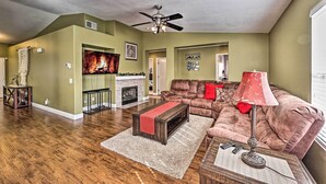 A living room with a fireplace, a sofa, a coffee table, and a ceiling fan. - Incredible Wildomar Getaway w/ Outdoor Oasis! (Wildomar)