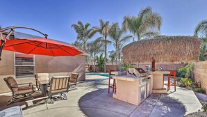 An outdoor patio with a barbecue area, seating, and a pool in the background. - Incredible Wildomar Getaway w/ Outdoor Oasis! (Wildomar)