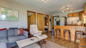 Ein modernes Wohnzimmer mit einem grauen Sofa, einem weißen Sessel und einem Holztisch.