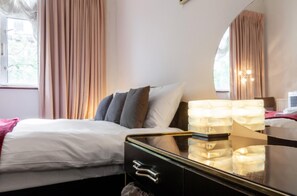 Relax in a serene space with a comfortable bed, side table, and large window offering a view.