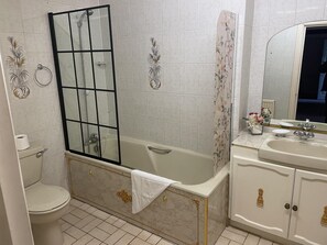 Une salle de bain équipée d’une baignoire, de toilettes et d’un espace douche.