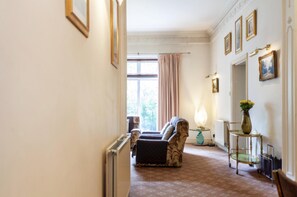 Relax in a peaceful space with a sofa set near a large window overlooking lush greenery.