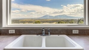 A kitchen sink with a view of a mountain landscape through a window. - Sauna & Views: Southern Colorado Vacation Rental! (Walsenburg)
