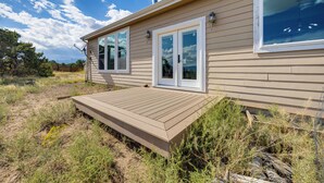 A house with a deck, large windows, and a chimney. - Sauna & Views: Southern Colorado Vacation Rental! (Walsenburg)