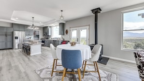 A spacious kitchen with modern appliances, a dining area with a round table and chairs, and a view of mountains through a large window. - Sauna & Views: Southern Colorado Vacation Rental! (Walsenburg)