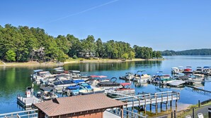 A marina with various boats docked, surrounded by a forested shoreline. - Resort-style Condo w/ Balcony on Lake Keowee (Salem)