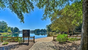 A stone pathway leading to a private beach with a signboard, surrounded by trees and a calm lake. - Resort-style Condo w/ Balcony on Lake Keowee (Salem)