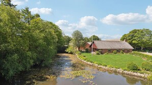 A riverside property with a house, lush greenery, and a calm water body. - Nice home in Bækmarksbro with WiFi (Bækmarksbro)
