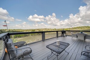 Eine Terrasse mit Gartenmöbeln, einem Tisch und Blick auf einen Weinberg.