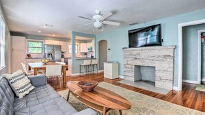 A modern living room with a gray sofa, wooden coffee table, and a fireplace. - Modern Seaview House - 200 Yards to Daytona Beach! (Daytona Beach)
