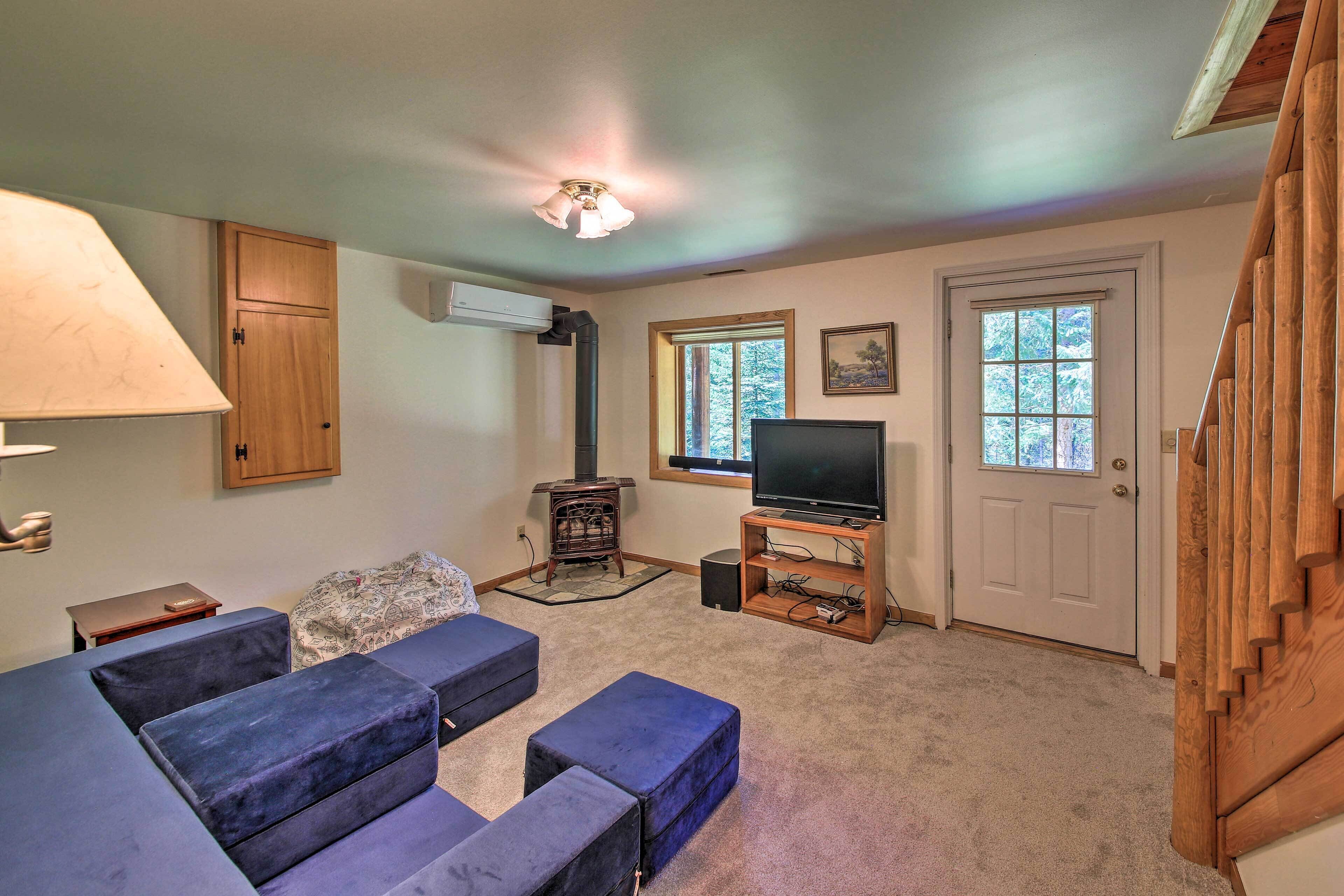 A living room with a television, a fireplace, and a staircase.