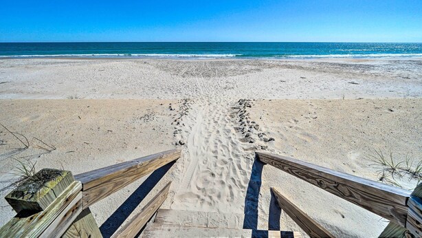 A sandy beach with a wooden walkway leading to the water. - Spacious North Topsail Family Home With 2 Decks (Sneads Ferry)