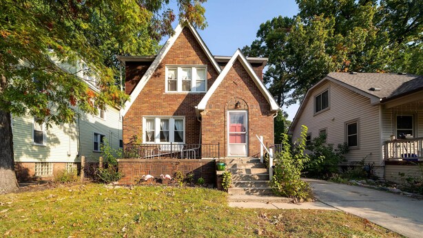 A two-story house with a brick exterior, a front porch, and a small front yard. - Ferndale Apartment w/ Yard - Near the Detroit Zoo! (Ferndale)