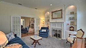 A spacious living room with a blue armchair, a wooden coffee table, and a fireplace. - Patio & Covered Porch: Spacious Bellevue Home! (Bellevue)