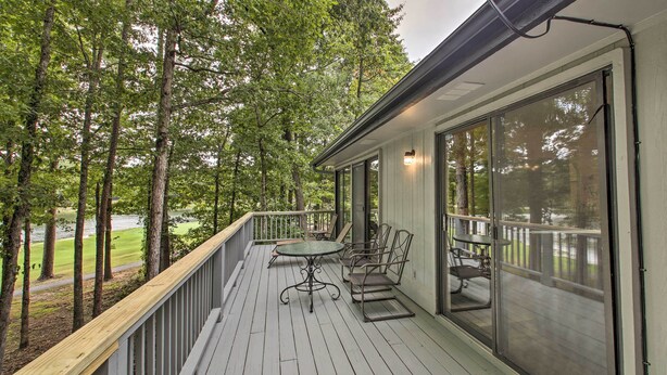 A wooden deck with a table and chairs, overlooking a lake and surrounded by trees. - Furnished Deck & Grill: Hot Springs House (Hot Springs Village)
