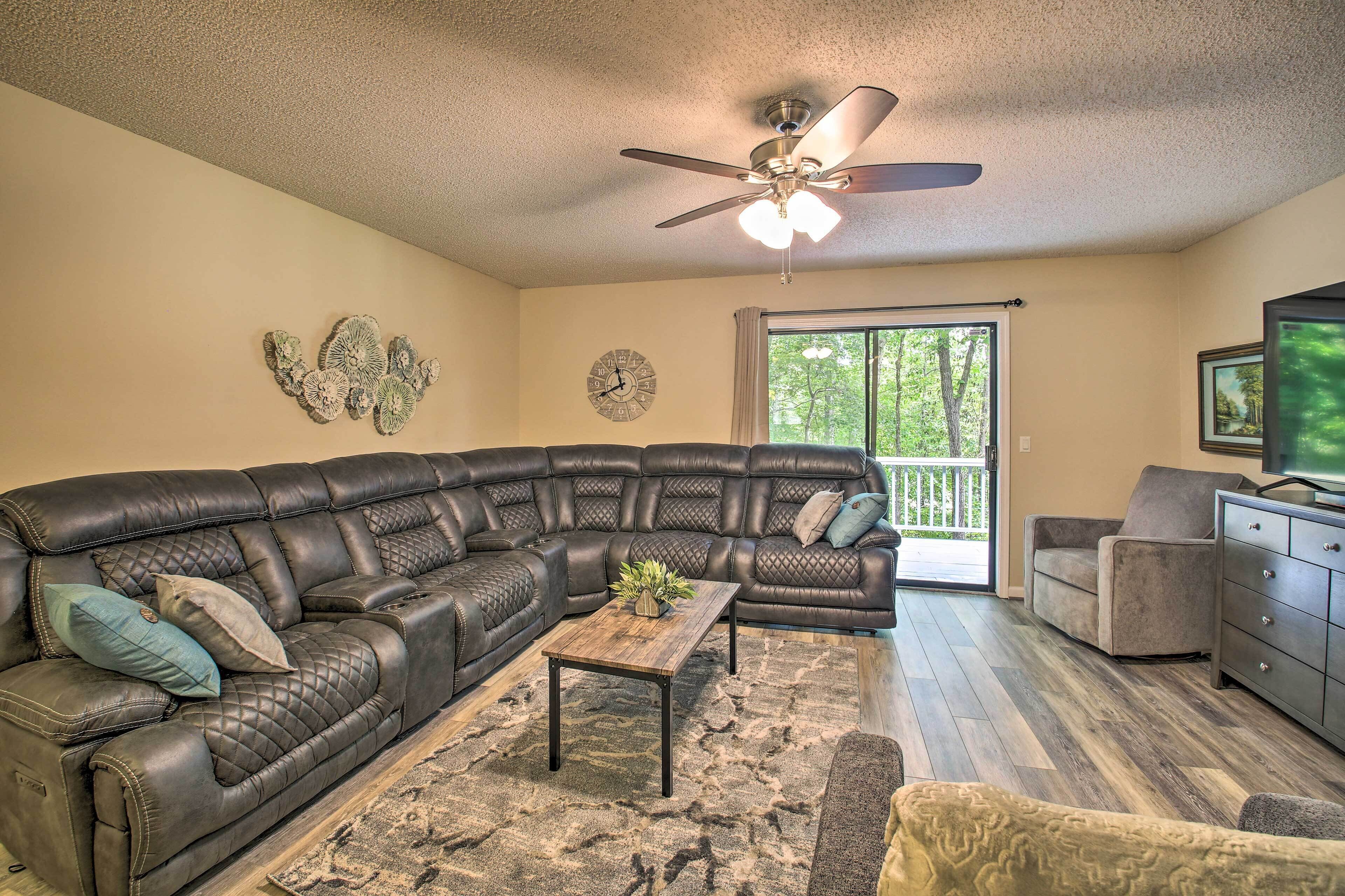 A living room with a sectional sofa, a coffee table, and a ceiling fan.
