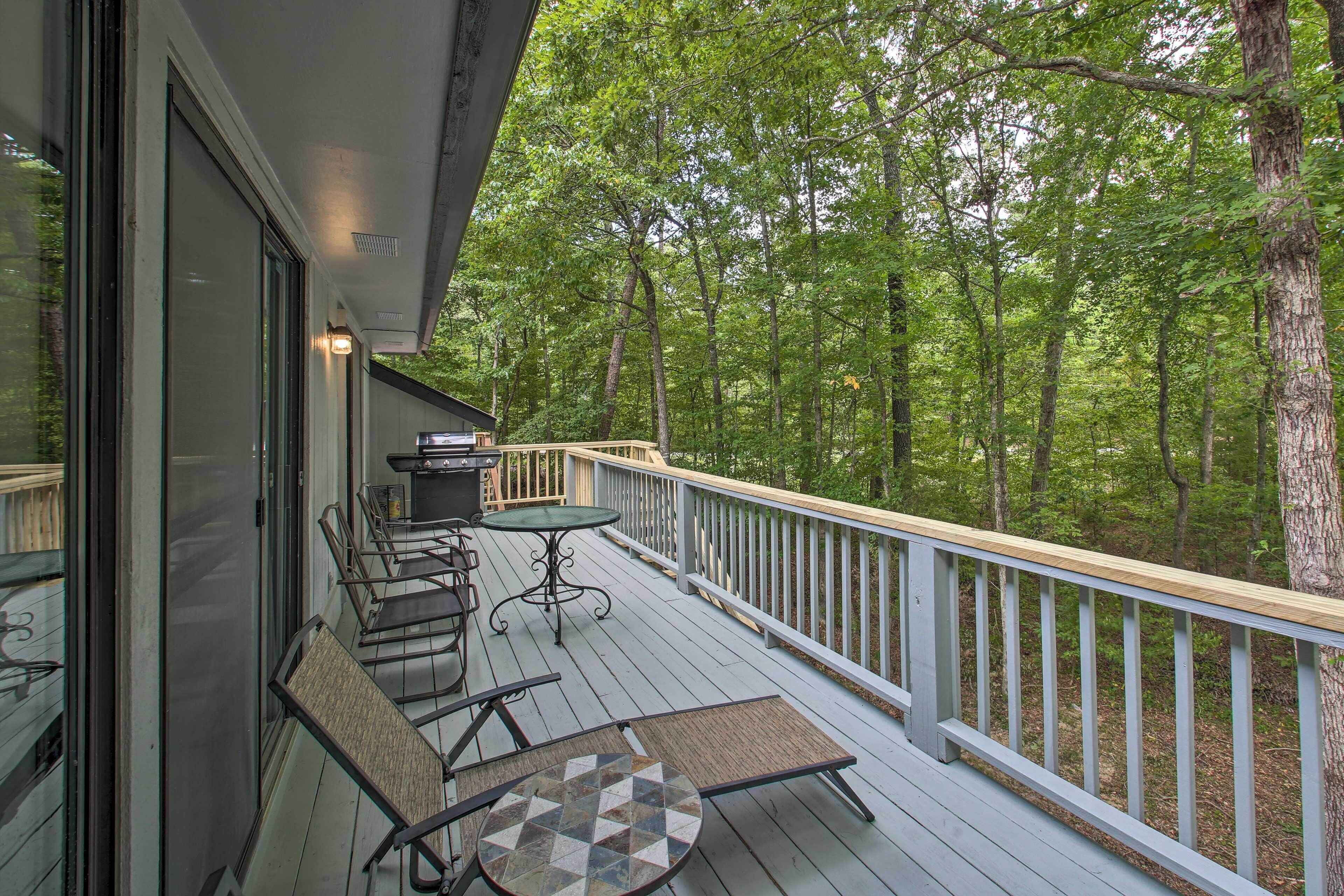 Une terrasse en bois avec des meubles d’extérieur, une table et des chaises.