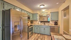 A kitchen with light blue cabinets, stainless steel appliances, and a wooden floor. - Furnished Deck & Grill: Hot Springs House (Hot Springs Village)