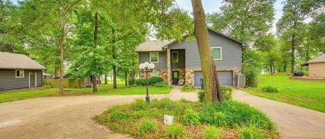 A residential house with a front yard, driveway, and a garage.