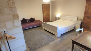 Ein Schlafzimmer mit einem Bett, Nachttischen, einer Lampe, einem Holzstuhl und einem kleinen Tisch.
