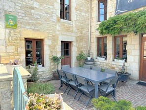 Relax in this serene outdoor space with a patio featuring a table, chairs, and a soothing fountain.