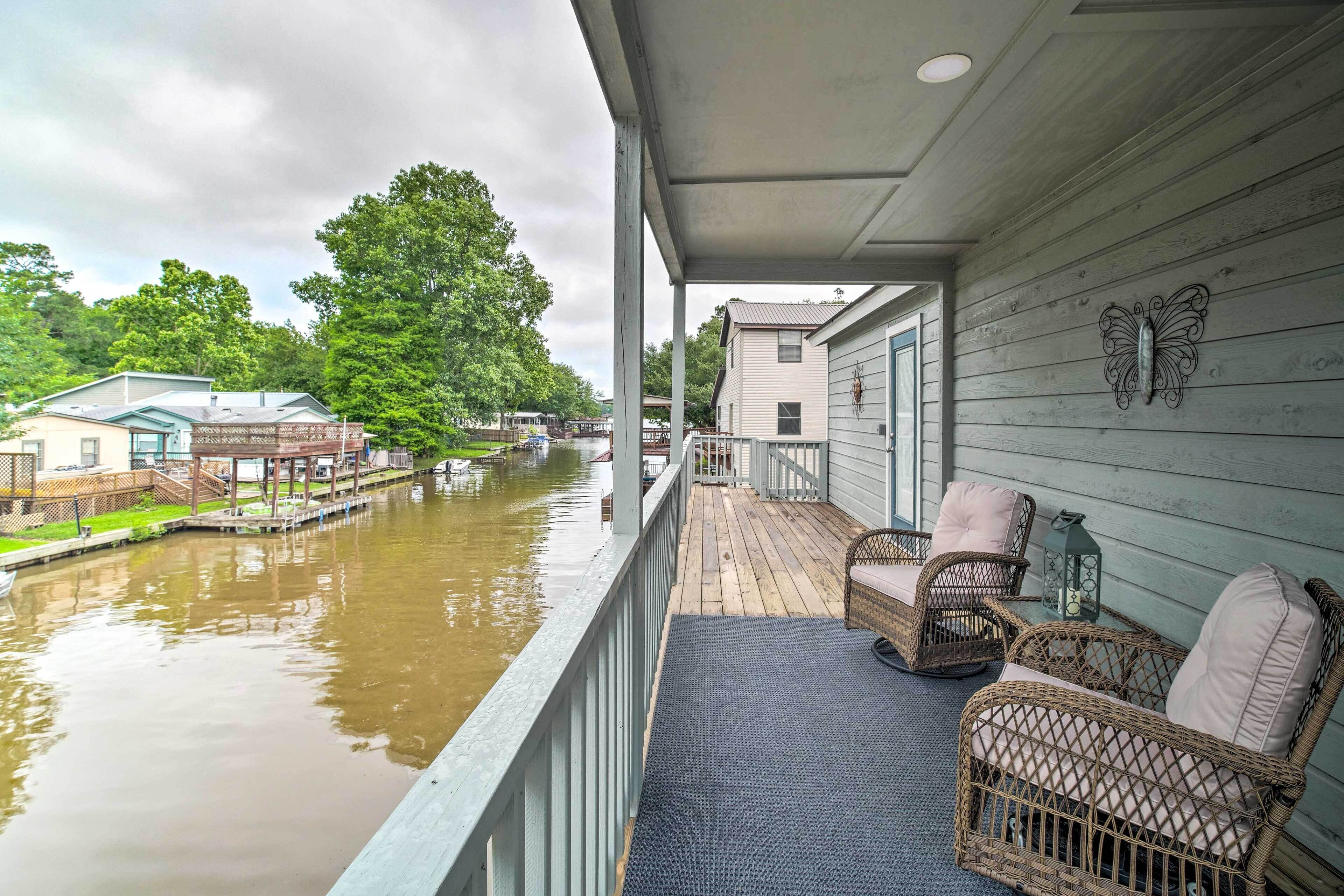 Ein überdachter Balkon mit Korbmöbeln und Blick auf einen Fluss.
