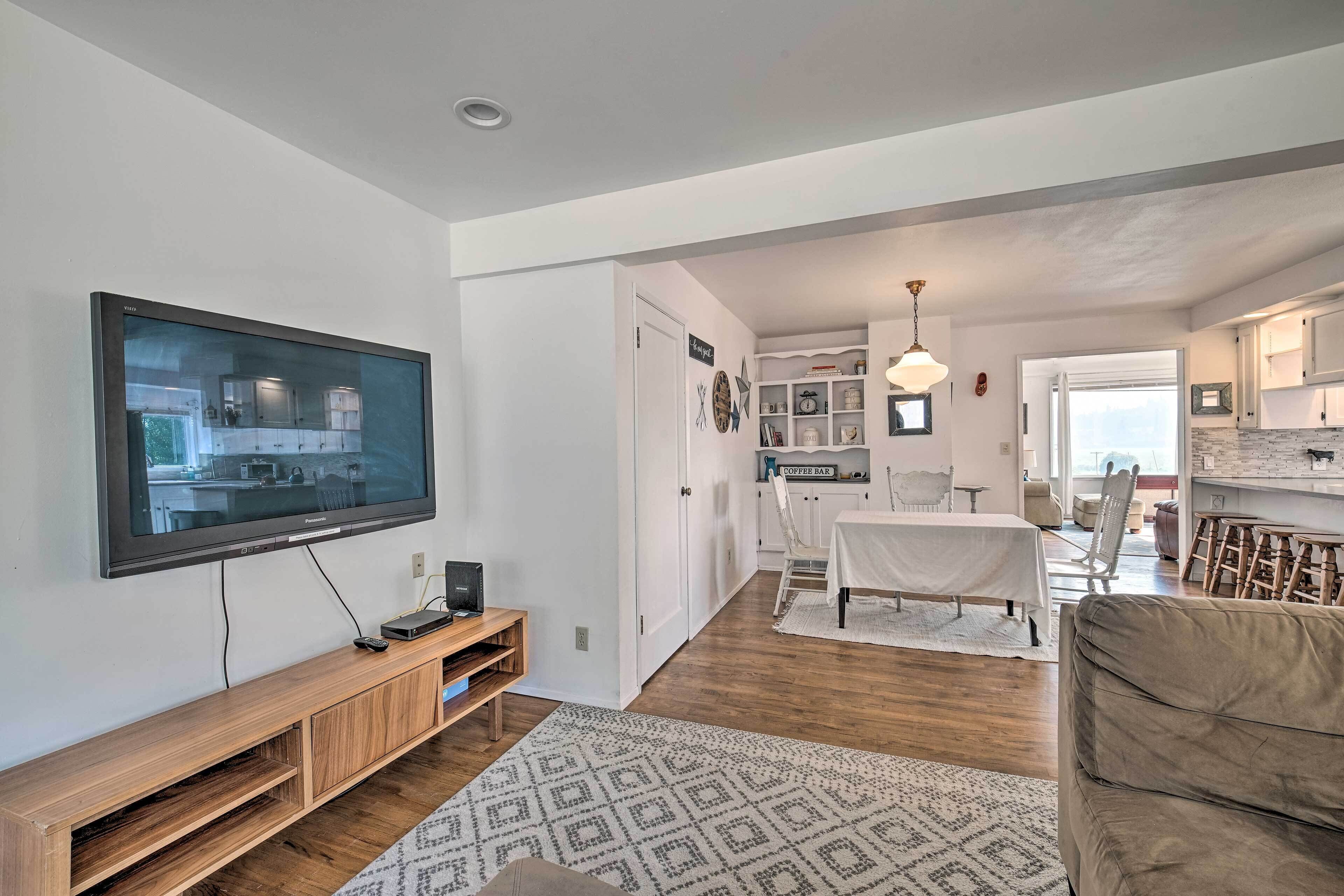 Una sala de estar moderna con un televisor de pantalla plana, mueble de madera para entretenimiento y una alfombra estampada.