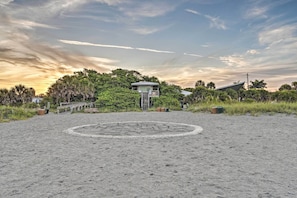 A beach with a lifeguard tower, a circular stone pattern, and a house with a sloped roof. - Updated Apartment Walking Distance to Venice Beach (Venice)