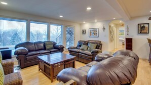 A spacious living room with leather sofas, a wooden coffee table, and large windows. - Grand Junction Abode ~ 2 Miles to Wineries & Golf! (Grand Junction)