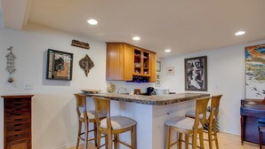 A kitchen with a central island, wooden bar stools, and a piano. - Grand Junction Abode ~ 2 Miles to Wineries & Golf! (Grand Junction)
