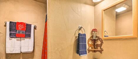 A bathroom with a sink, mirror, and towels.