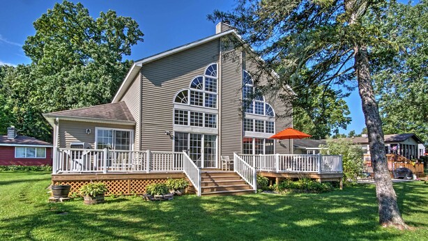 A two-story house with a deck, large windows, and a well-maintained lawn. - Waterfront Vandalia House w/ Dock on Donnell Lake! (Vandalia)