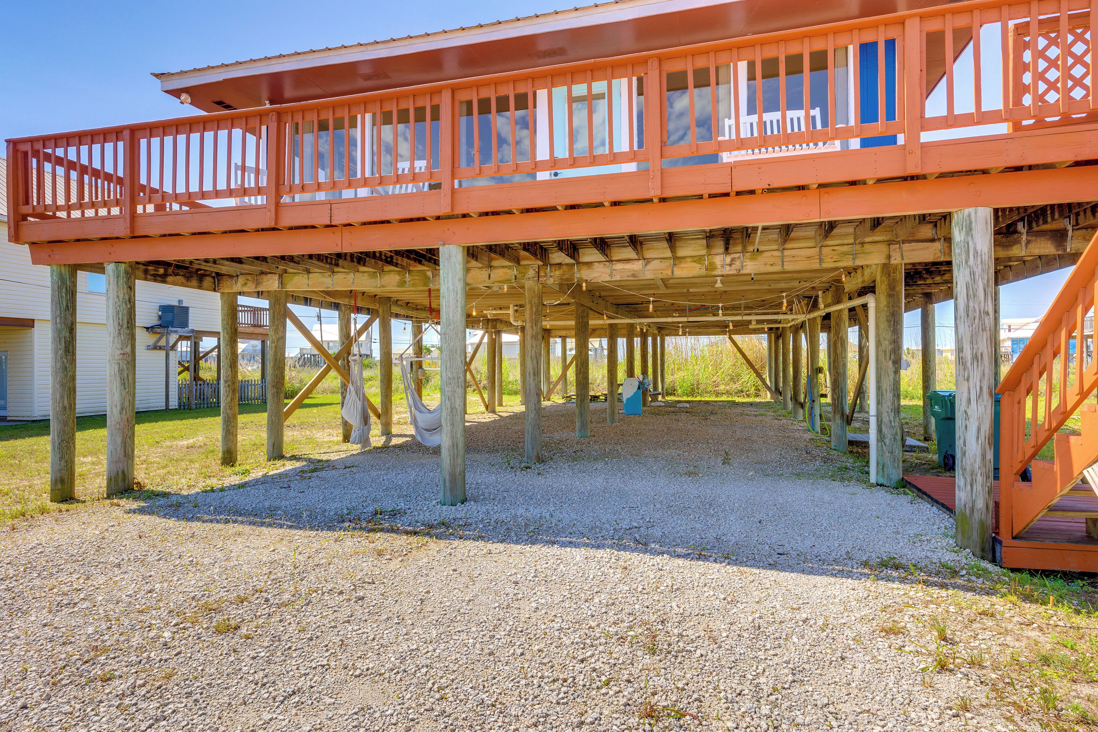 A wooden deck structure with railings and a gravel ground.
