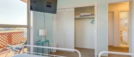 A hotel room with a bed, a TV, a closet, and a balcony.