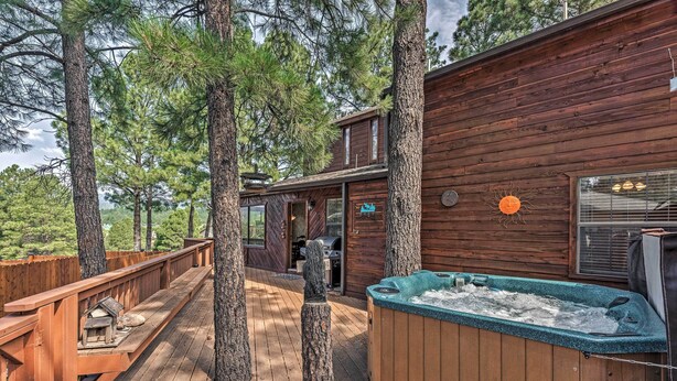 A wooden deck with a hot tub, surrounded by trees. - Cozy Ruidoso Cabin w/ Private Hot Tub & Large Deck (Ruidoso)