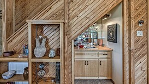 A wooden interior with a kitchen area, including wooden cabinets, a sink, and various kitchen utensils. - Cozy Ruidoso Cabin w/ Private Hot Tub & Large Deck (Ruidoso)