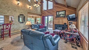 A spacious living room with leather sofas, a fireplace, and a television. - Cozy Ruidoso Cabin w/ Private Hot Tub & Large Deck (Ruidoso)