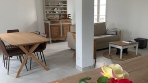 Uma sala de estar moderna com área de jantar, sofá e mesa de centro.