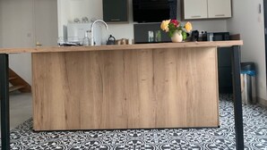 Uma cozinha moderna com uma ilha central, micro-ondas e pia.