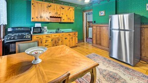 Eine Küche mit Holzschränken, einem Edelstahlkühlschrank, einer Mikrowelle und einem Herd.