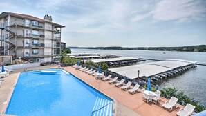 A hotel with a swimming pool, outdoor seating, and a view of the water.