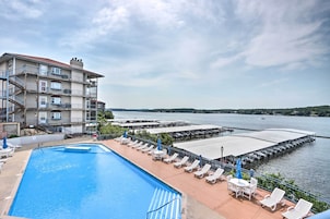 Un hotel con piscina, mobiliario exterior y vistas al agua.