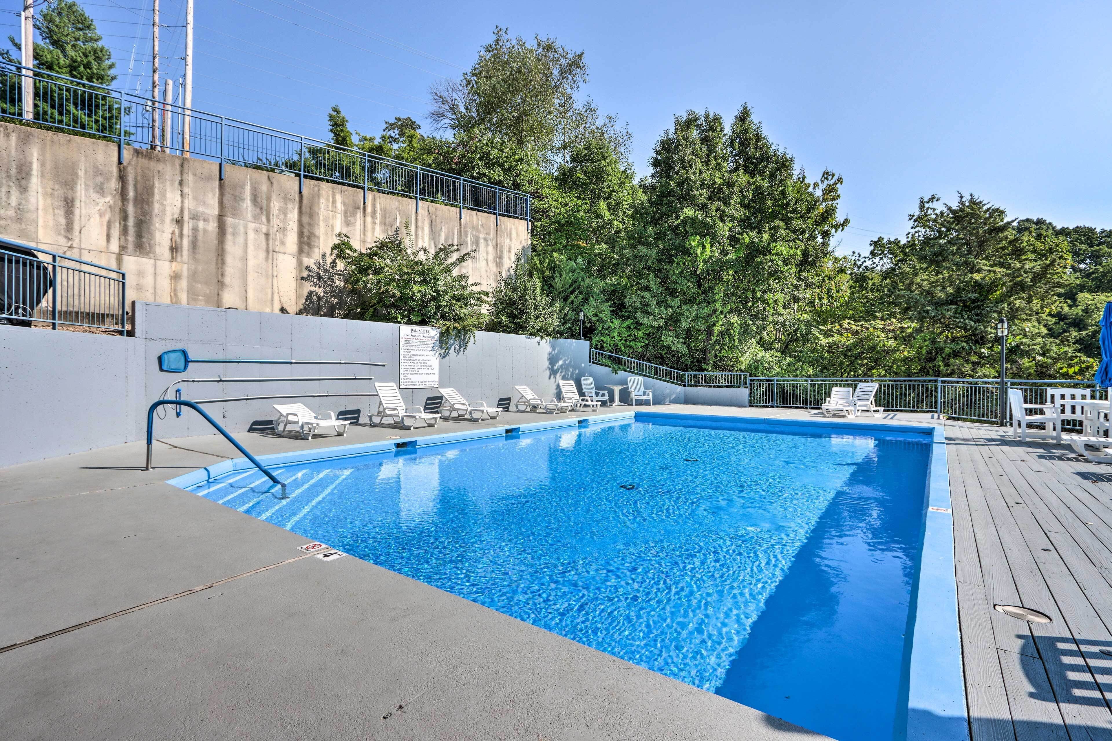 A rectangular swimming pool with clear blue water, surrounded by a wooden deck.