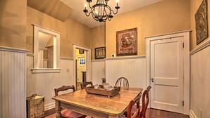 A dining room with a wooden table, chairs, a chandelier, and a door. - Ely Getaway Near Town, Lakes, & Outdoor Recreation (Ely)