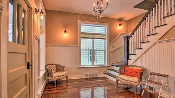 A spacious living room with hardwood flooring, a staircase, and two upholstered chairs. - Ely Getaway Near Town, Lakes, & Outdoor Recreation (Ely)
