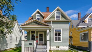 A two-story house with a front porch, a chimney, and a small front yard. - Ely Getaway Near Town, Lakes, & Outdoor Recreation (Ely)