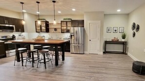 A modern kitchen with a central island, stainless steel appliances, and pendant lighting. - Private Guesthouse close to Nashville (Mt. Juliet)